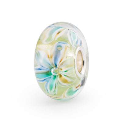 Stunning glass bead featuring a whimsical flower design in green, blue, turquoise and yellow colors. 