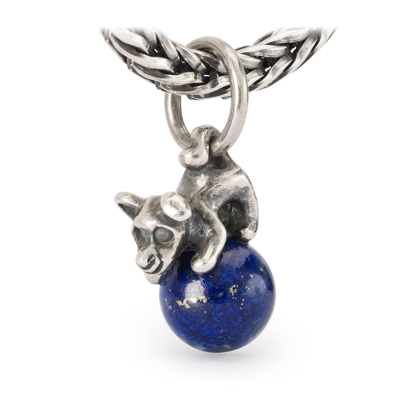 Silver tassel of a happy dog on a ball of Lapis lazuli.