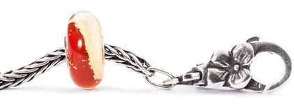 Silver charm with a red and gold bead on a white background