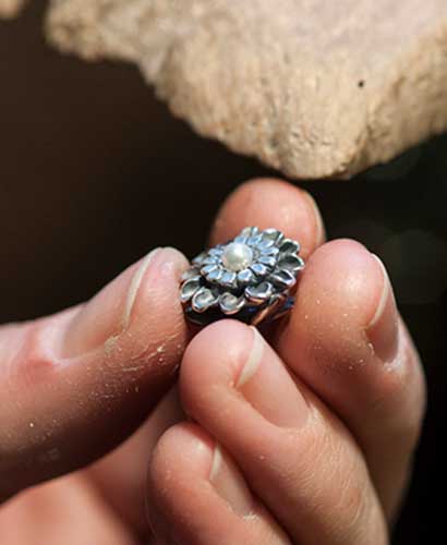 A hand holding a finished Trollbeads bead
