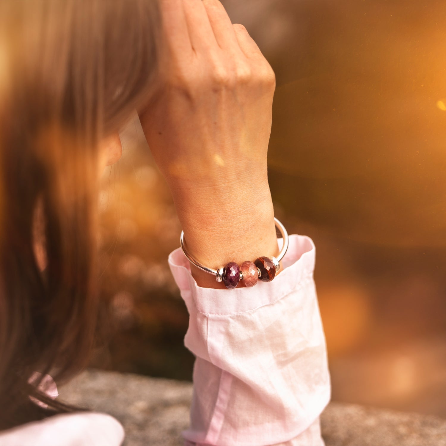 Person wearing a bracelet with red beads with a blurred background