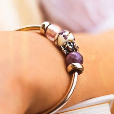 Close-up of a bracelet styled with barrel beads and purple accents.