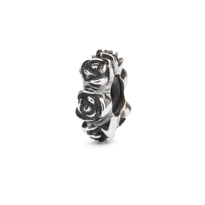 Rose Spacer features a delicate design of roses all over. The spacer is made of sterling silver and has a cylindrical shape.