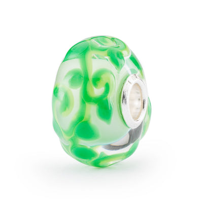 A beautiful glass bead featuring a mesmerizing design reminiscent of a magic bean, with a swirl design in green.
