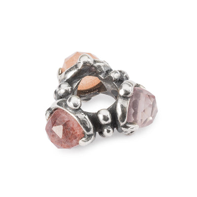 The Trinity of the Heart bead has a triangular shape. Three gemstones on each end of the triangular framed by silver.