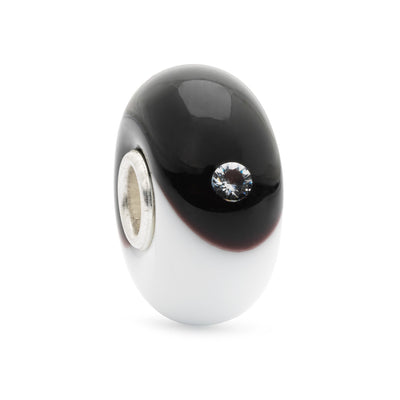 Perfect Balance Bead is made of glass, featuring two interlocking circles symbolizing balance and harmony in white and black embedded with two cubic zirconias on each side.